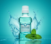 A vibrant mouthwash blog feature image showcasing a bottle of mouthwash, fresh mint leaves, water splashes, and a smiling person with sparkling teeth, highlighting oral health benefits and freshness.