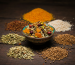 A feature image showing colorful mukhwas ingredients on a rustic surface with a bowl of mixed mukhwas in the center.