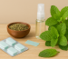Mint mouth freshener with mint leaves, strips, spray bottle, and herbal seeds on a wooden surface
