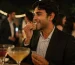 Person using Mountain Breeze mouth freshener strip after drinks at an office party with cocktails in the background