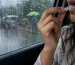 Woman using Mountain Breeze mouth freshener strip during monsoon rain to fight humidity-related bad breath